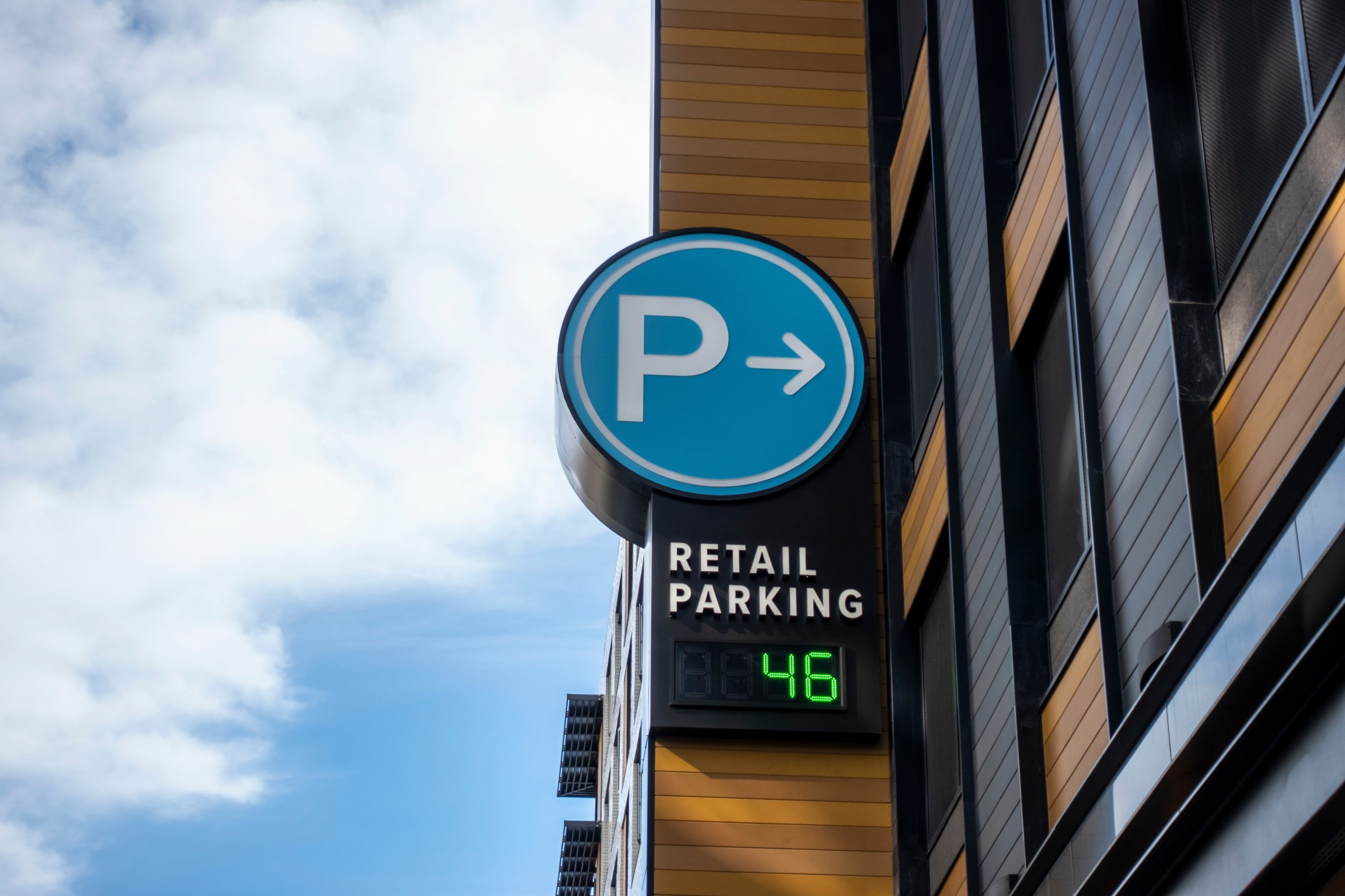 Low angle view of a baby blue digital parking sign for a parking garage in a shopping district downtown
