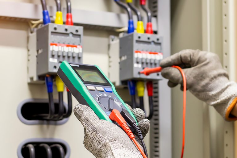 Engineers working to inspect and maintain electrical control cabinets.